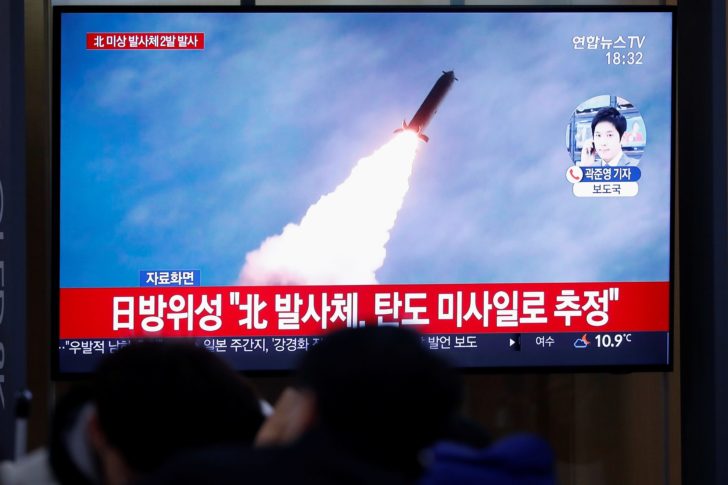 People watch a TV broadcasting file footage for a news report on North Korea firing an unidentified projectile, in Seoul