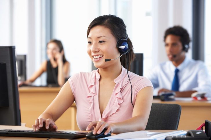Friendly call center agent using headset and computer