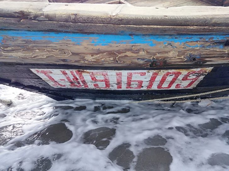Numbers and letters are seen on a wooden boat containing human remains and suspected to be from North Korea, according to a Coast Guard official, along a shore of Sado island