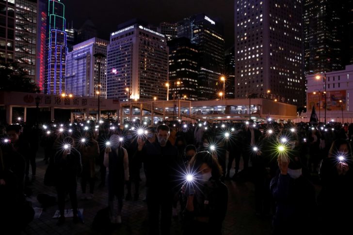Anti-government demonstrators use the flashlights of their mobile phones as they take part in a protest in Edinburgh Place in Hong Kong