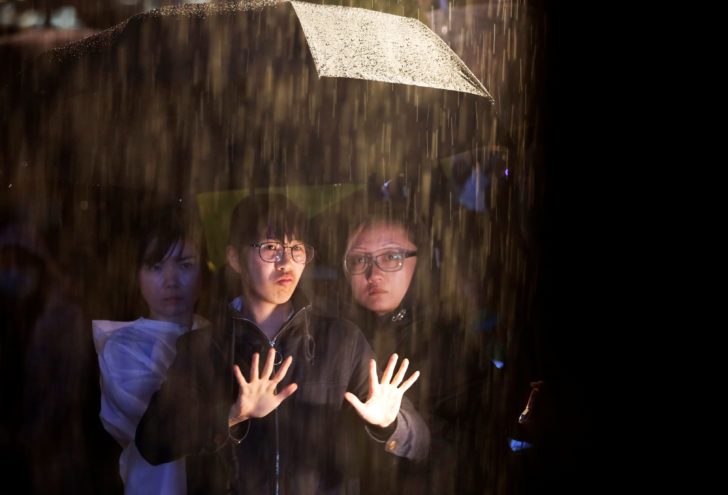 A woman uses a sign language to translate a speech amidst the rain during a rally at Edinburgh Place in Hong Kong