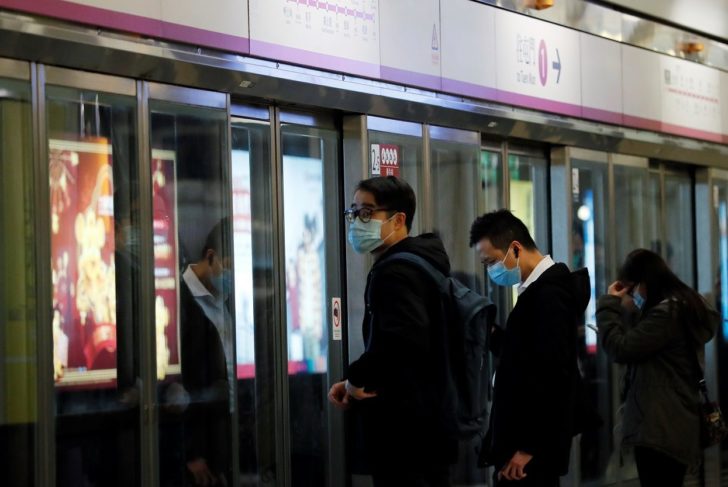 Passengers wear mask to prevent a new coronavirus outbreak, as they wait for a Mass Transit Railway (MTR) subway train in Hong Kong