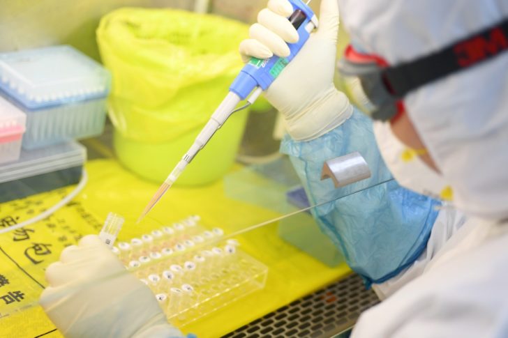 Worker in protective suit examines specimens inside a laboratory following an outbreak of the novel coronavirus in Wuhan