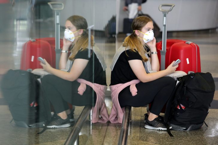 A woman wearing mask reacts at Kuala Lumpur International Airport in Sepang