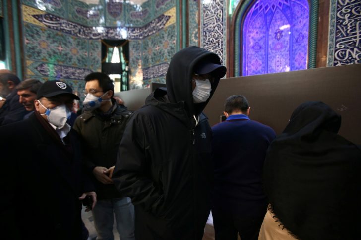 Men wear face masks during parliamentary elections at a polling station in Tehran
