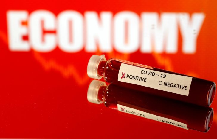 Fake blood is seen in a test tube labelled with the coronavirus (COVID-19) in front of the word