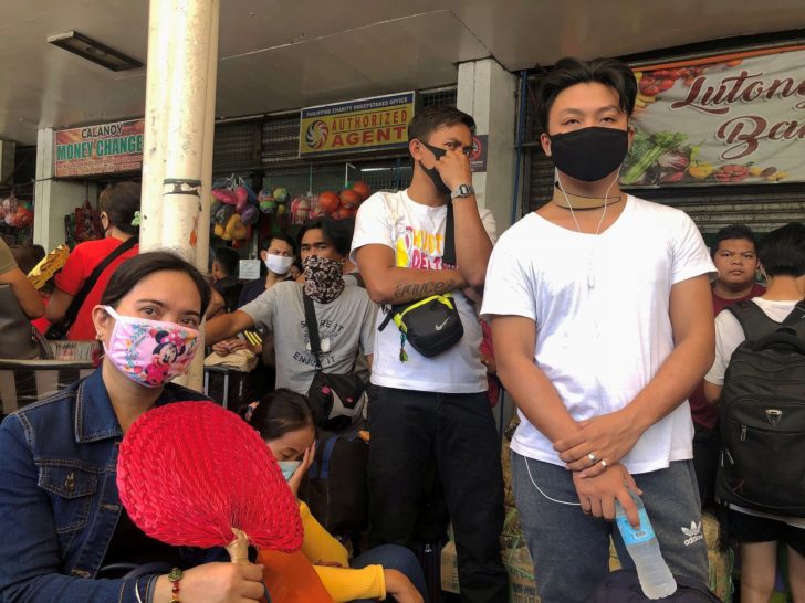 Passengers wear protective masks while waiting at the Araneta Center Bus Terminal in Cubao, Quezon City