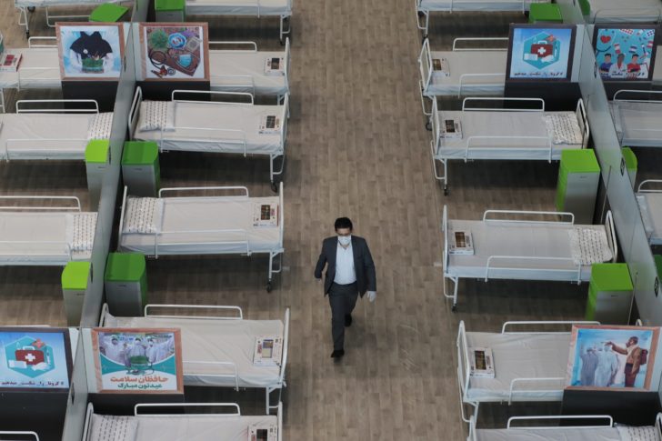 A man walks between beds at a shopping mall, one of Iran's largest, which has been turned into a centre to receive patients suffering from the coronavirus disease (COVID-19), in Tehran