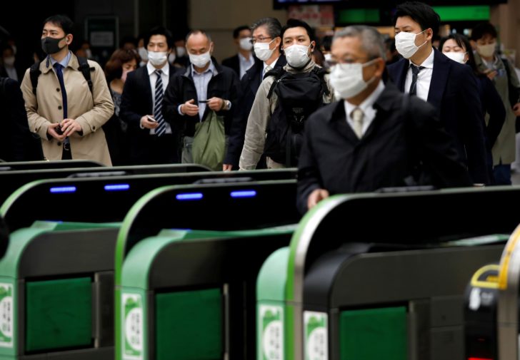 Passengers wearing protective face masks, following an outbreak of the coronavirus disease, are seen at a station after the government announced the state of emergency for the capital following the disease outbreak in Tokyo, Japan