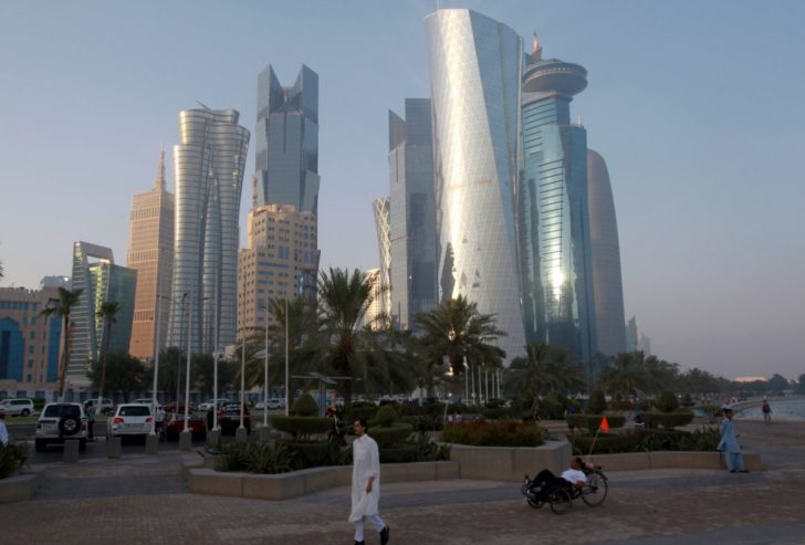 FILE PHOTO: A man walks on the corniche in Doha