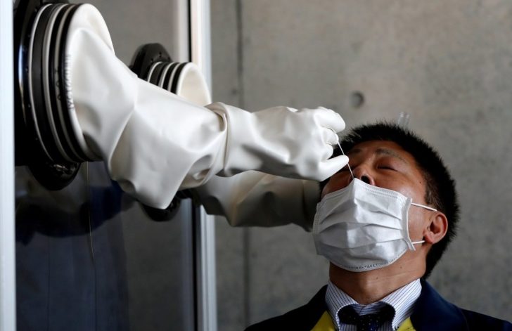 FILE PHOTO: A medical worker conducts a simulation for a walk-in style PCR test for the coronavirus disease (COVID-19), at Yokosuka, south of Tokyo,