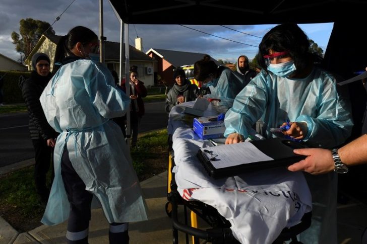 Medical professionals work with members of the public at a COVID-19 testing facility in Melbourne