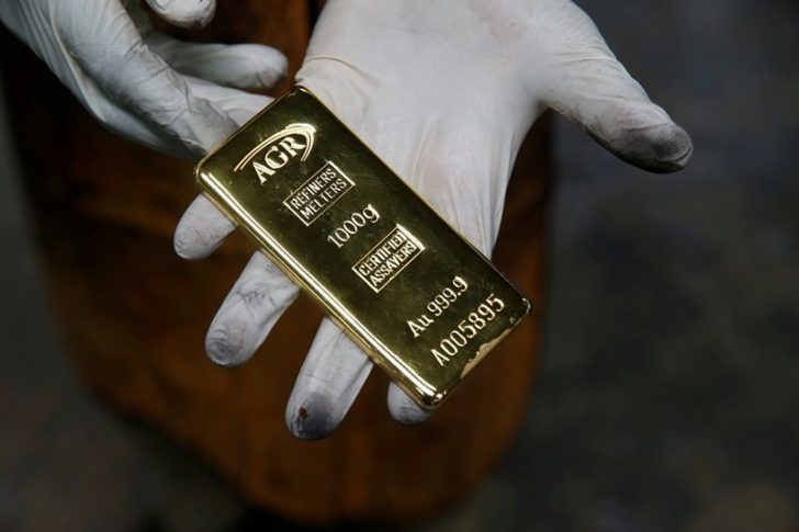 FILE PHOTO: An employee holds a 1kg gold bar at AGR (African Gold Refinery) in Entebbe