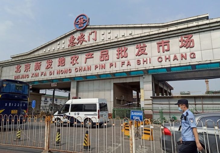 Police officer wearing a face mask is seen outside an entrance of the Xinfadi wholesale market, which has been closed for business after new coronavirus infections were detected, in Beijing
