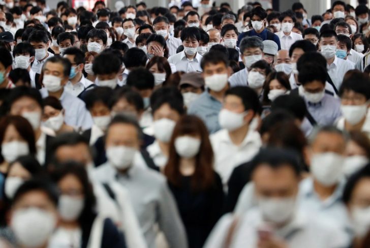 People wearing protective masks amid the coronavirus disease (COVID-19) outbreak, make their way during rush hour at a railway station in Tokyo