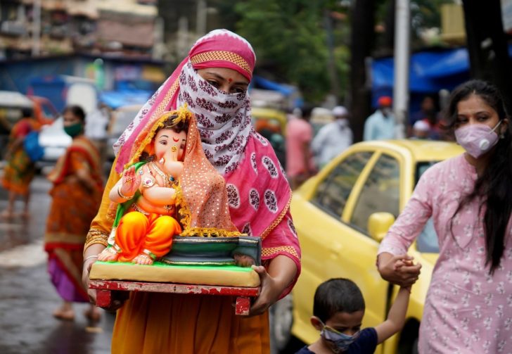 A woman carries an idol of Hindu god Ganesh to her home on the first day of the ten-day-long Ganesh Chaturthi festival in Mumbai