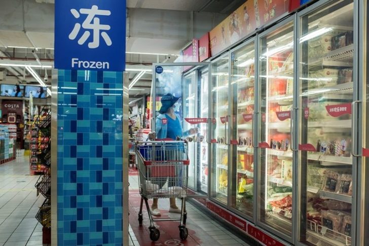 A woman looks at frozen food products in a supermarket in Beijing