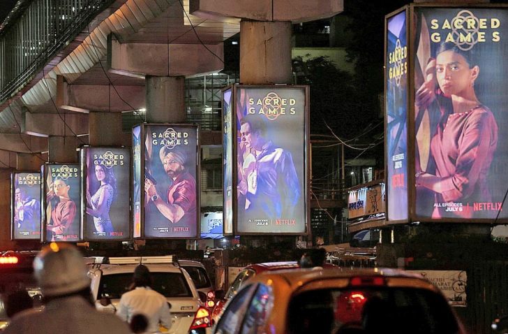 FILE PHOTO: Traffic moves on a road past hoardings of Netflix television series