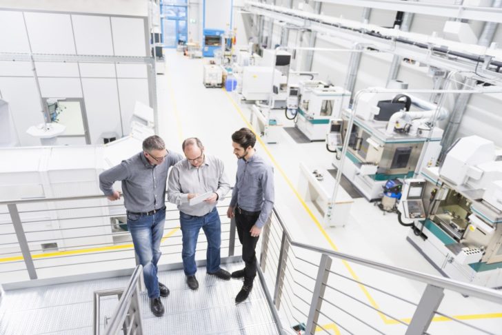 Engineers discussing notes on factory stairway