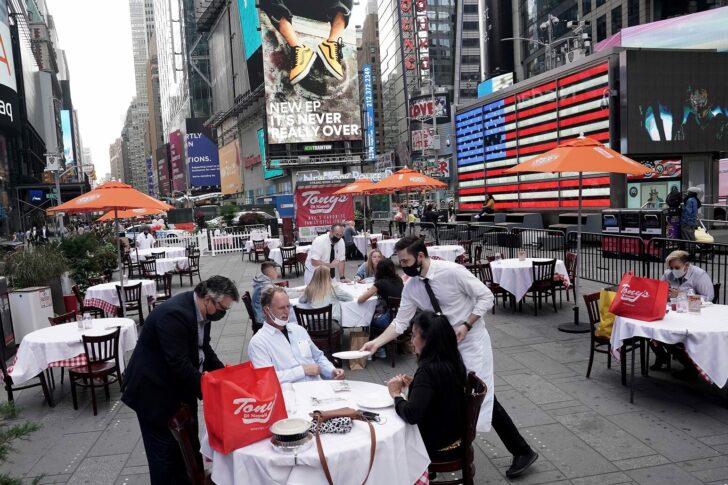 Servers deliver food to a table at a pop up restaurant set up in Times Square in New York