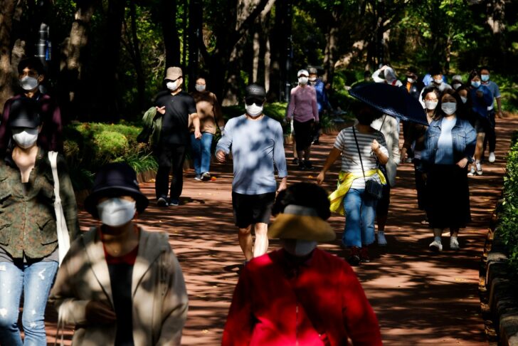 People take a walk as they wear masks to avoid the spread of the coronavirus disease (COVID-19) at a park in Seoul