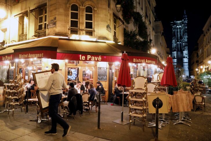 A staff member prepares to close a restaurant minutes before the late-night curfew in Paris