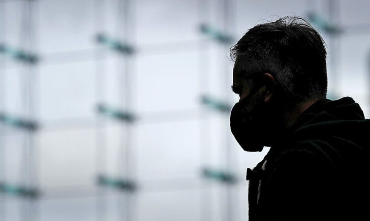 A commuter wearing a face mask is silhouetted at the main train station Hauptbahnhof, as the spread of the coronavirus disease (COVID-19) continues, in Berlin
