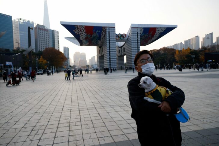 Man holding a pet dog takes a walk in Seoul