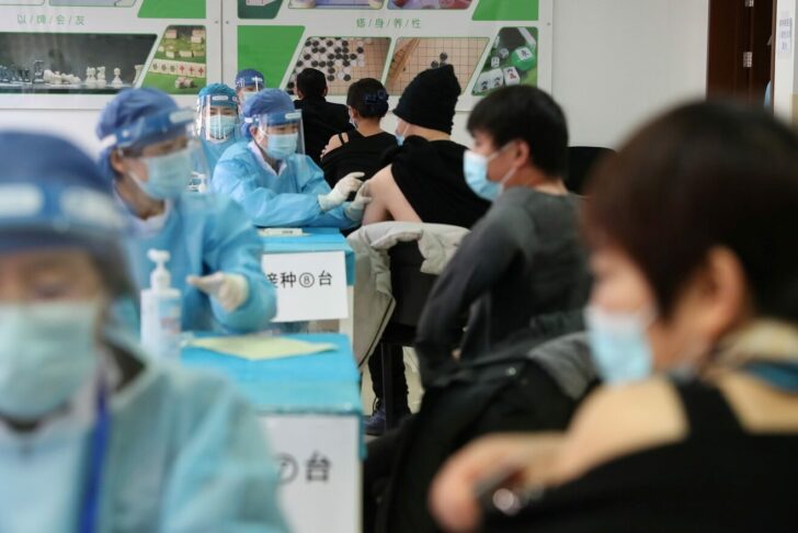 Medical workers administer COVID-19 vaccine at a makeshift vaccination site in Beijing