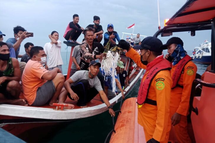 Local fishermen and rescuers hold suspected remains of the Sriwijaya Air plane flight SJ182, which crashed into the sea near Jakarta