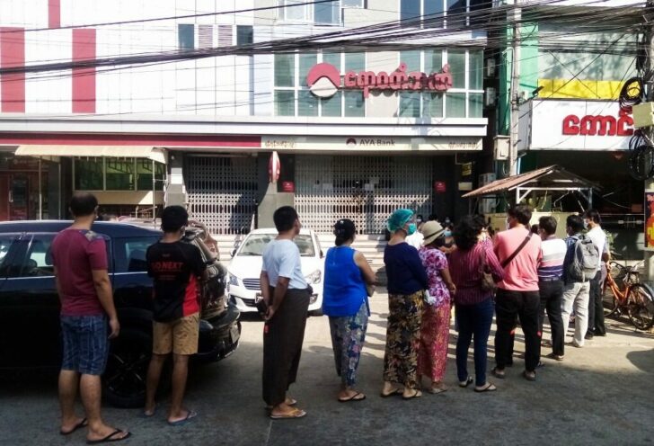 People line up outside a bank branch in Yangon