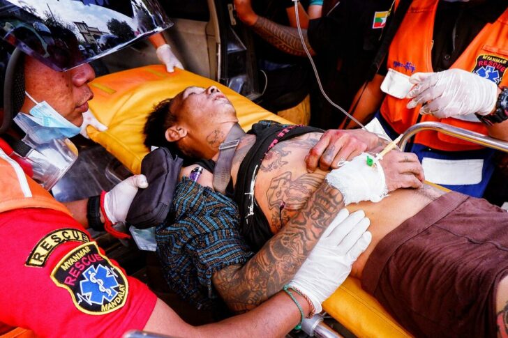 An injured man is carried by rescue workers after protests against the military coup, in Mandalay