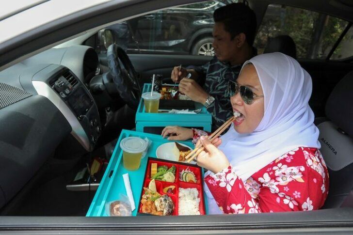 Customers dine in their car outside Padi House restaurant, during a lockdown due to the coronavirus disease (COVID-19) outbreak, in Cyberjaya