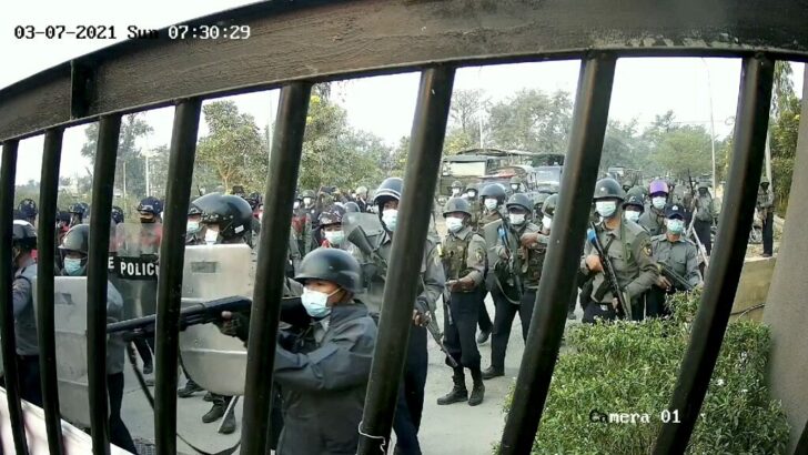 Police officers towards a gate of the Mandalay Technological University