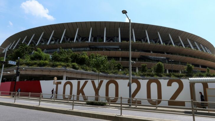 FILE PHOTO: People walk outside the security fence of Olympic Stadium (National Stadium) built for Tokyo Olympic Games