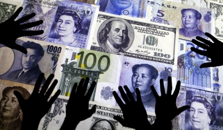 FILE PHOTO: Picture illustration of hands silhouetted against a backdrop projected with the picture of various currencies of money