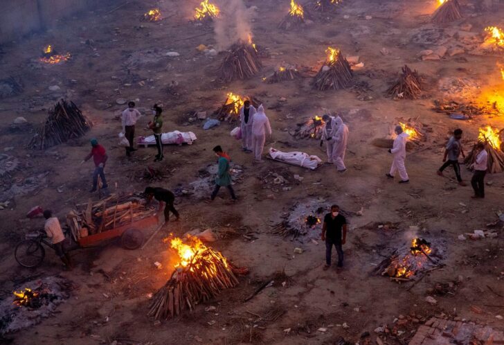 FILE PHOTO: People wait to cremate COVID-19 victims at a crematorium ground in New Delhi