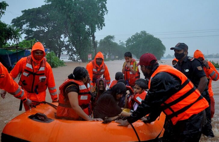 Rescue workers evacuate people from a flooded area to safer places after heavy rains in Kolhapur