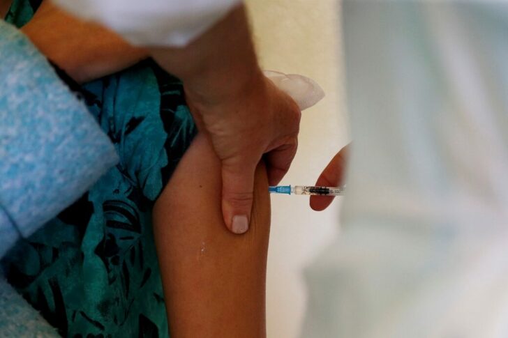 FILE PHOTO: A medical worker receives the Pfizer-BioNTech coronavirus disease (COVID-19) vaccine at Santa Maria hospital in Lisbon