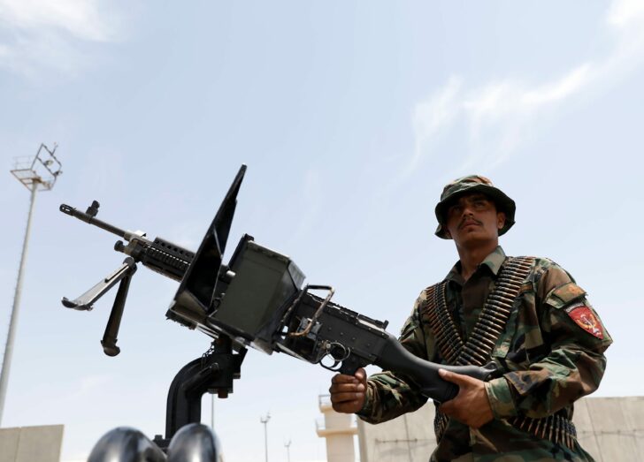 An Afghan security forces member keeps watch in an army vehicle in Bagram U.S. air base, after American troops vacated it, in Parwan province