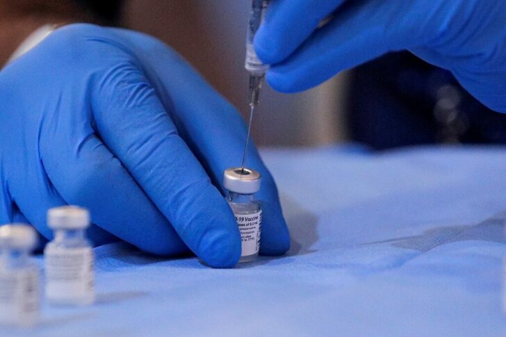 FILE PHOTO: A syringe is filled with a dose of Pfizer's coronavirus disease (COVID-19) vaccine at a pop-up community vaccination center in Valley Stream, New York