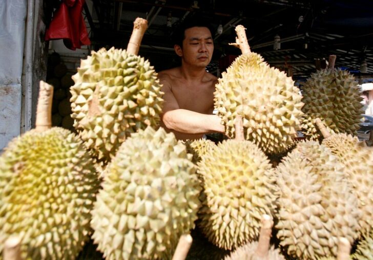 FILE PHOTO: A man arranges durians for sale at a roadside stall in Singapore
