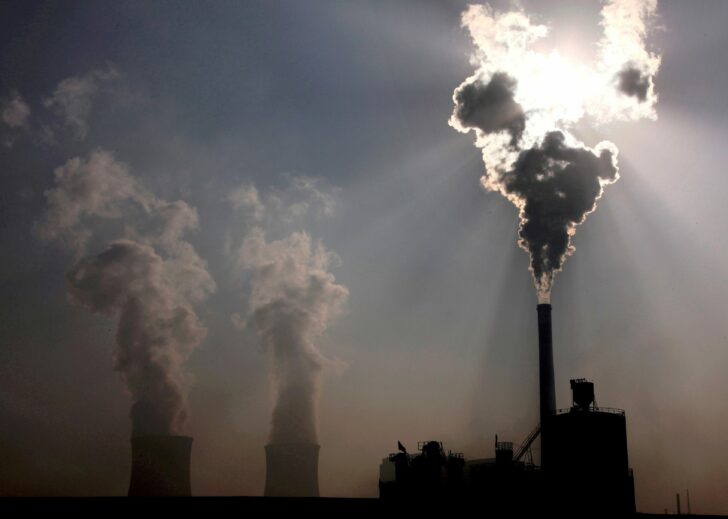 FILE PHOTO: FILE PHOTO: A coal-burning power plant can be seen behind a factory in the city of Baotou, in China's Inner Mongolia Autonomous Region