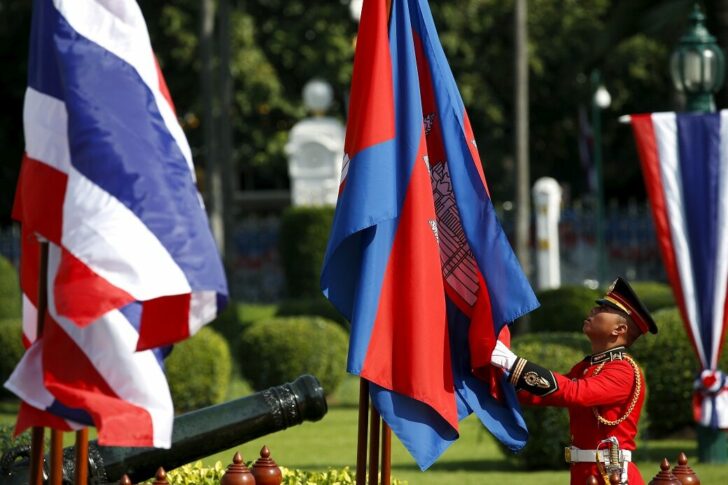 FILE PHOTO: An honour guard adjusts Cambodia's national flags before a welcoming ceremony at Government House in Bangkok