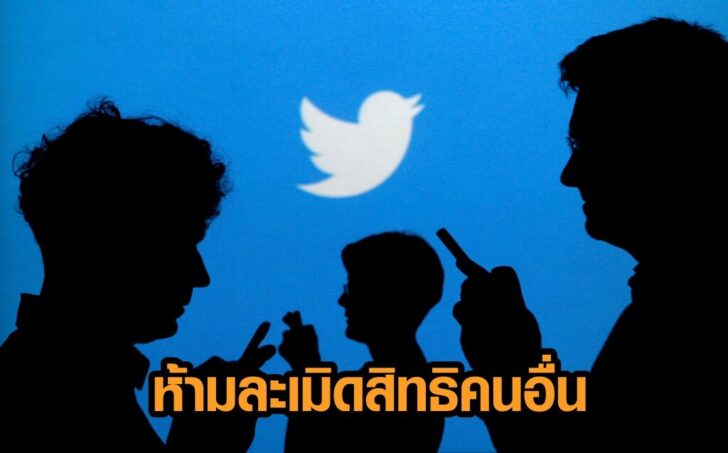 FILE PHOTO: People holding mobile phones are silhouetted against a backdrop projected with the Twitter logo