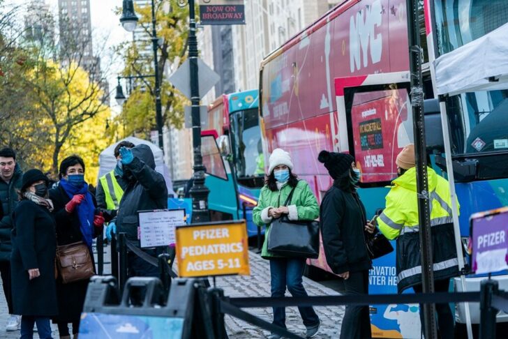 People wait in line outside a mobile vaccination bus in New York