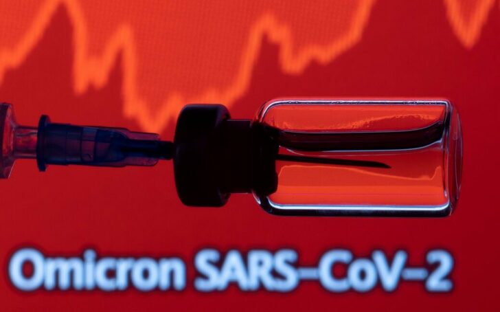 FILE PHOTO: A vial and a syringe are seen in front of a displayed stock graph and words