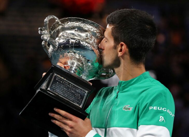 FILE PHOTO: Serbia's Novak Djokovic celebrates with the trophy after winning his ninth Australian Open title