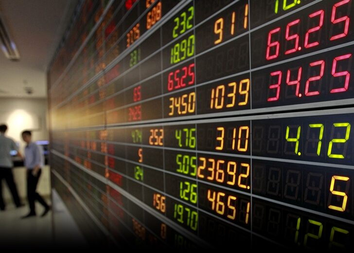 FILE PHOTO: An investor walks past an electronic board displaying live market data at a stock broker's office in central Bangkok