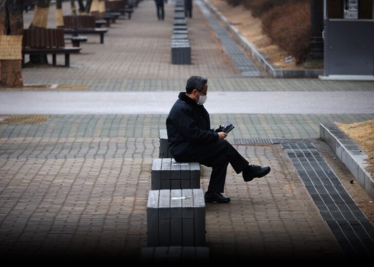 A man wearing a mask to prevent contracting the coronavirus disease (COVID-19) rests at an empty park in Seoul
